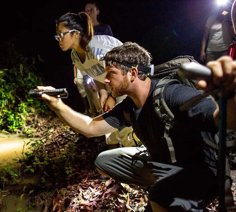 andrew snyder holding a flashlight in the field