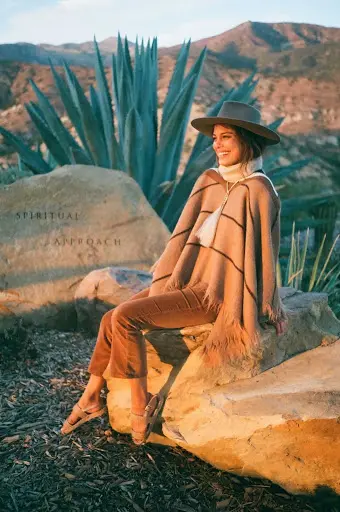 Nat Kelley sitting on a rock in the dessert